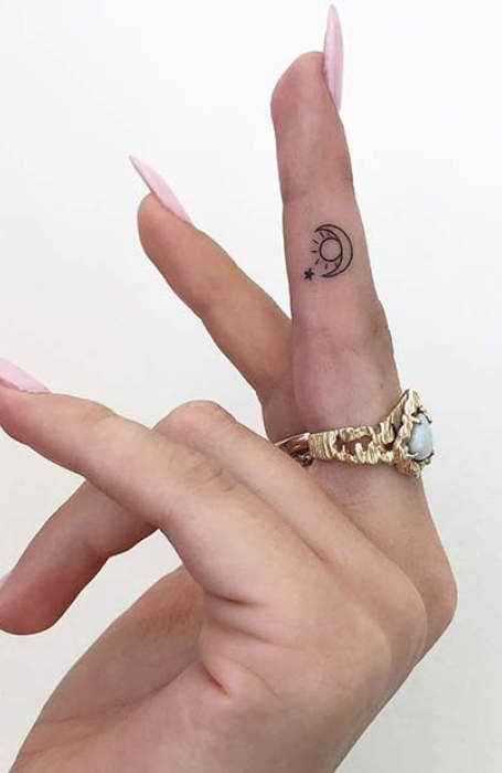 Tiny crescent moon and star tattoo on the side of the ring finger