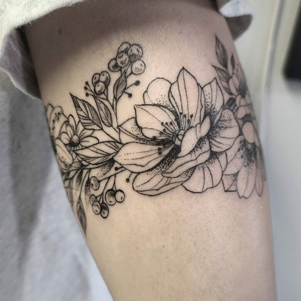 Elegant Floral Tattoo with Detailed Line Work on Upper Arm