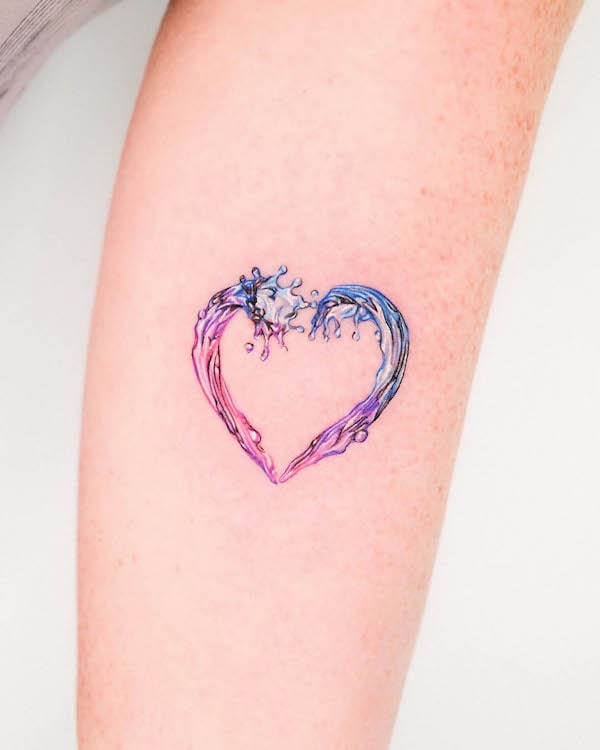 Water and fire heart tattoo with pink, purple, and blue hues on arm.