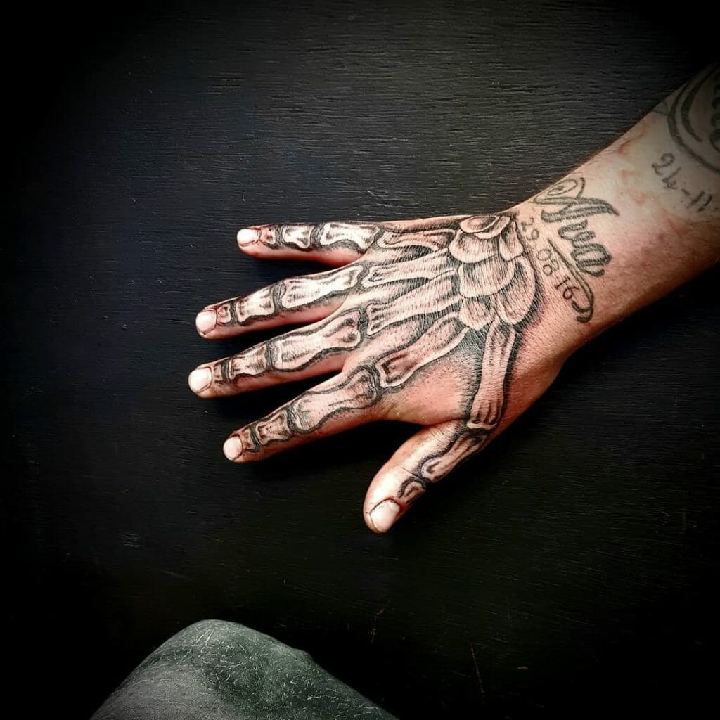 Detailed skeleton hand tattoo with realistic shading and intricate bone structure on the back of the hand