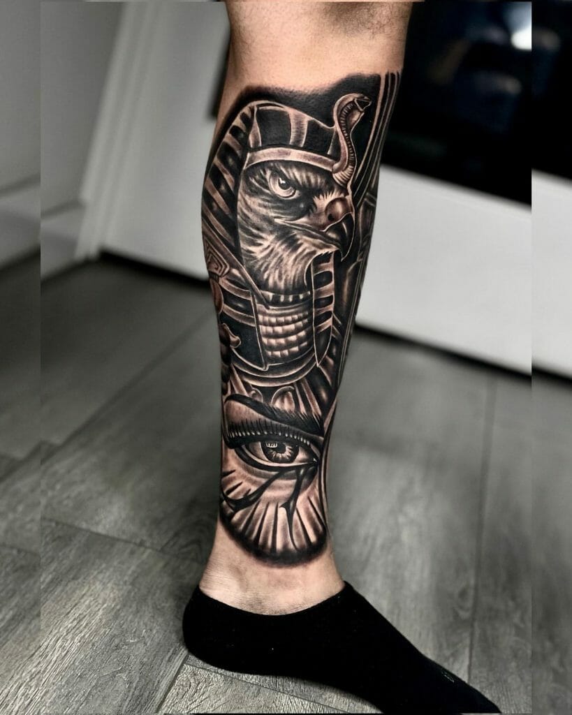 Egyptian-themed leg tattoo featuring a detailed falcon-headed pharaoh and the Eye of Horus in black and gray shading