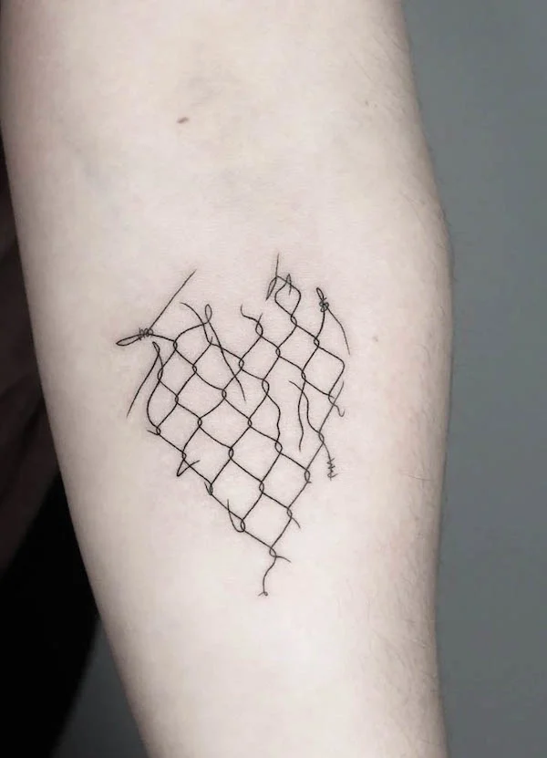 Minimalist heart-shaped barbed wire fence tattoo on forearm with black line design