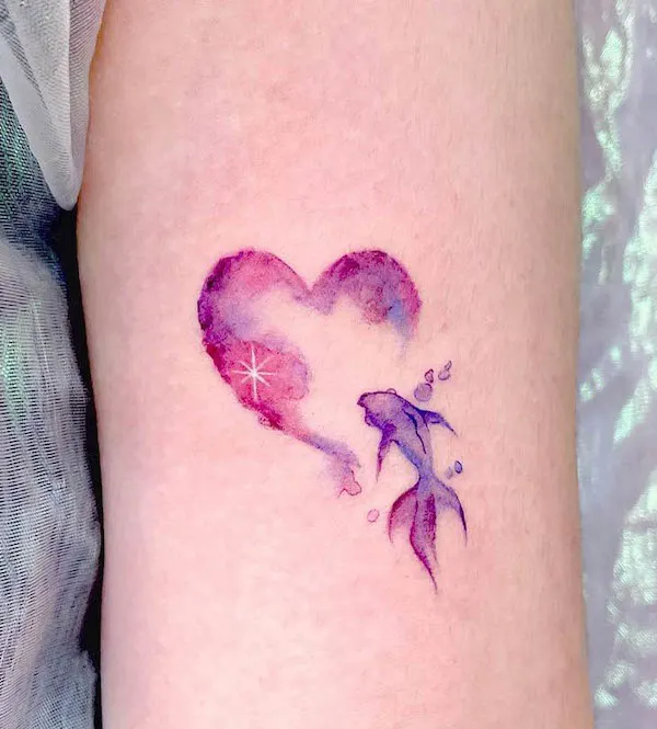 Watercolor heart tattoo with a purple fish swimming beside it, symbolizing love and fluidity