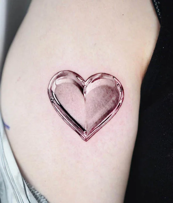 Glass heart tattoo with reflective details and soft pink shading