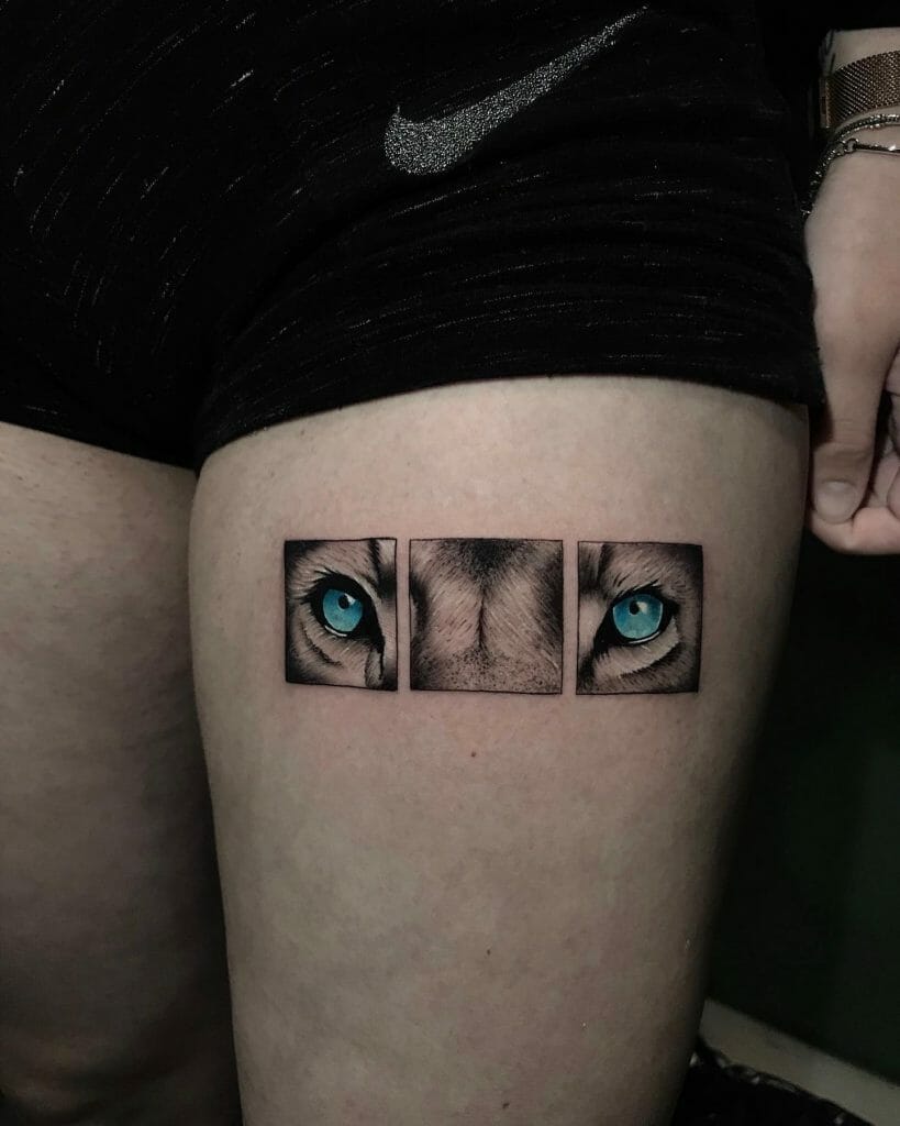 Thigh tattoo featuring a close-up of a lion's blue eyes in a triptych style, symbolizing focus, intensity, and inner strength.