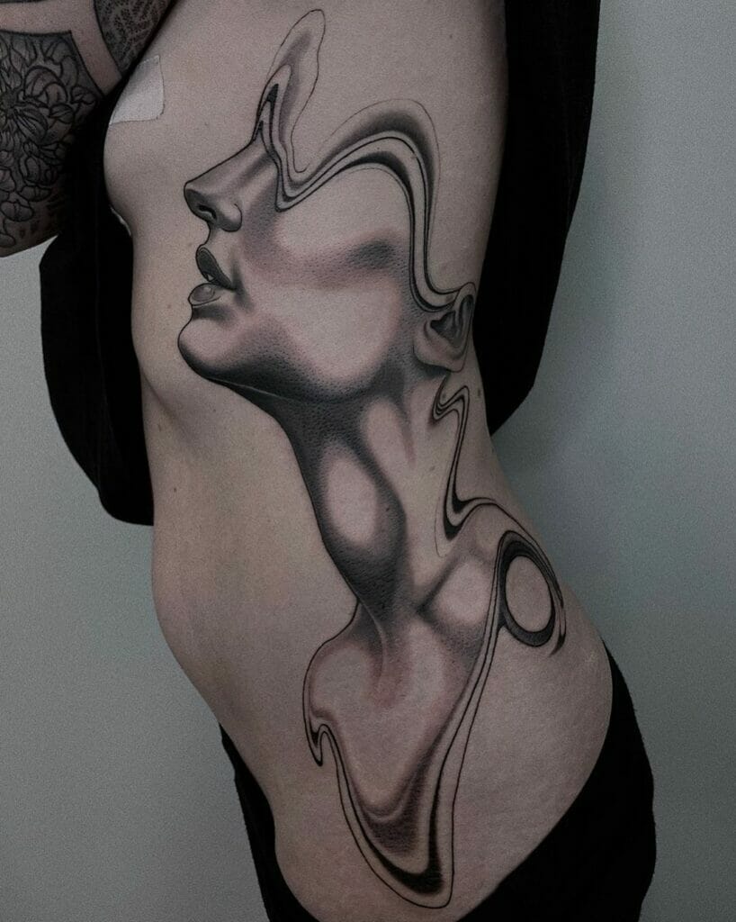 Abstract face tattoo with a surreal, fluid design blending black and gray shading on the rib area