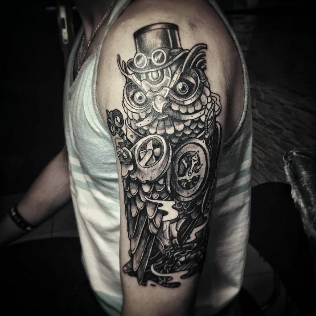 Steampunk owl tattoo featuring intricate gears, a top hat, and detailed black and gray shading on the upper arm