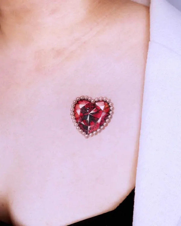 Red crystal heart tattoo with pearl border on chest