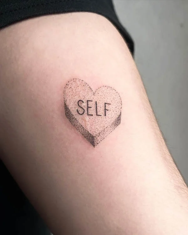 Self-love heart tattoo with dot-work shading and the word "SELF" inside symbolizing self-care and acceptance