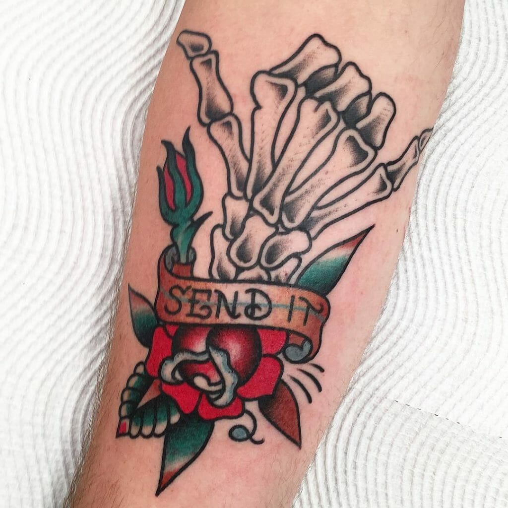 Traditional skeleton hand tattoo holding a rose with a banner reading 'Send It' in bold lettering