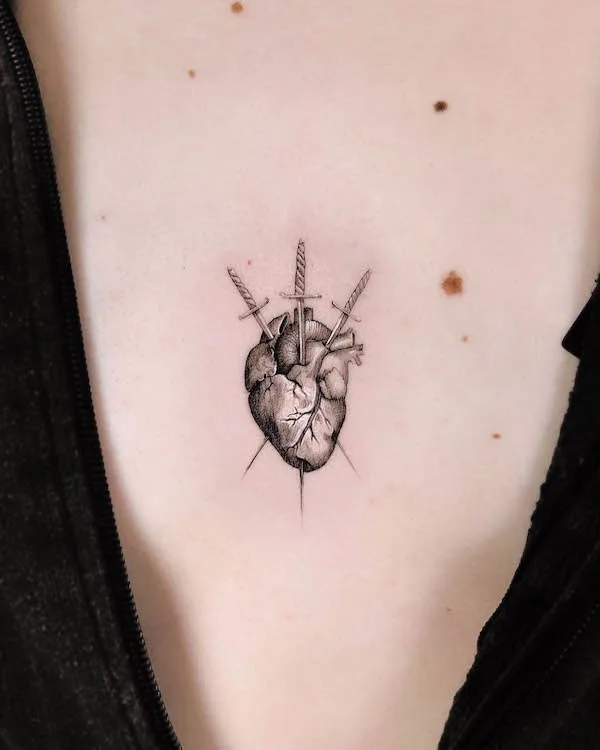 Anatomical heart tattoo pierced by three swords with detailed shading