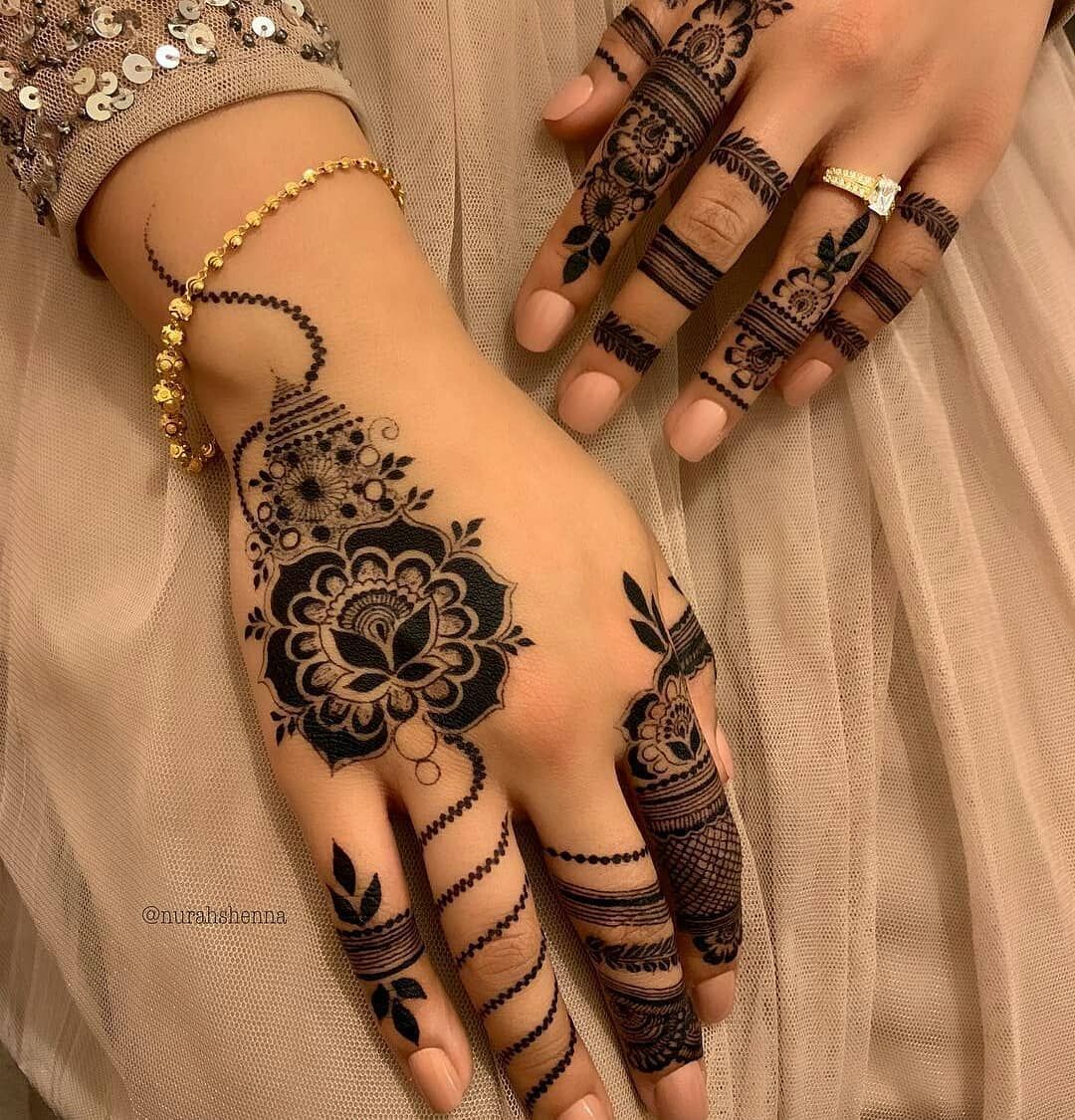 Traditional floral Mehndi design with bold flower patterns on the backhand and detailed finger designs featuring leafy and lined elements