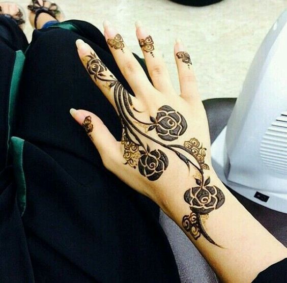 Minimalist Mehndi design featuring bold rose motifs and flowing vines along the back of the hand and fingers