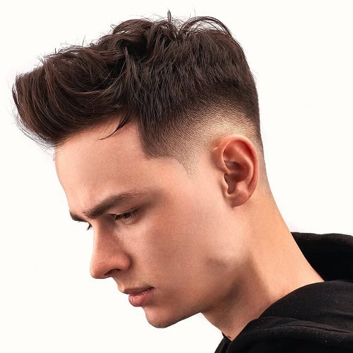 Young man with a textured crew cut hairstyle featuring a high fade, styled with volume on top