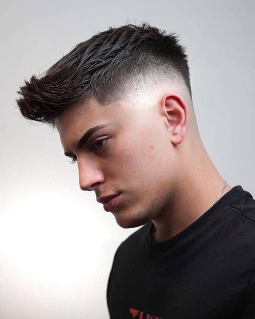 Man with a modern crew cut hairstyle featuring a high fade, styled with textured top hair