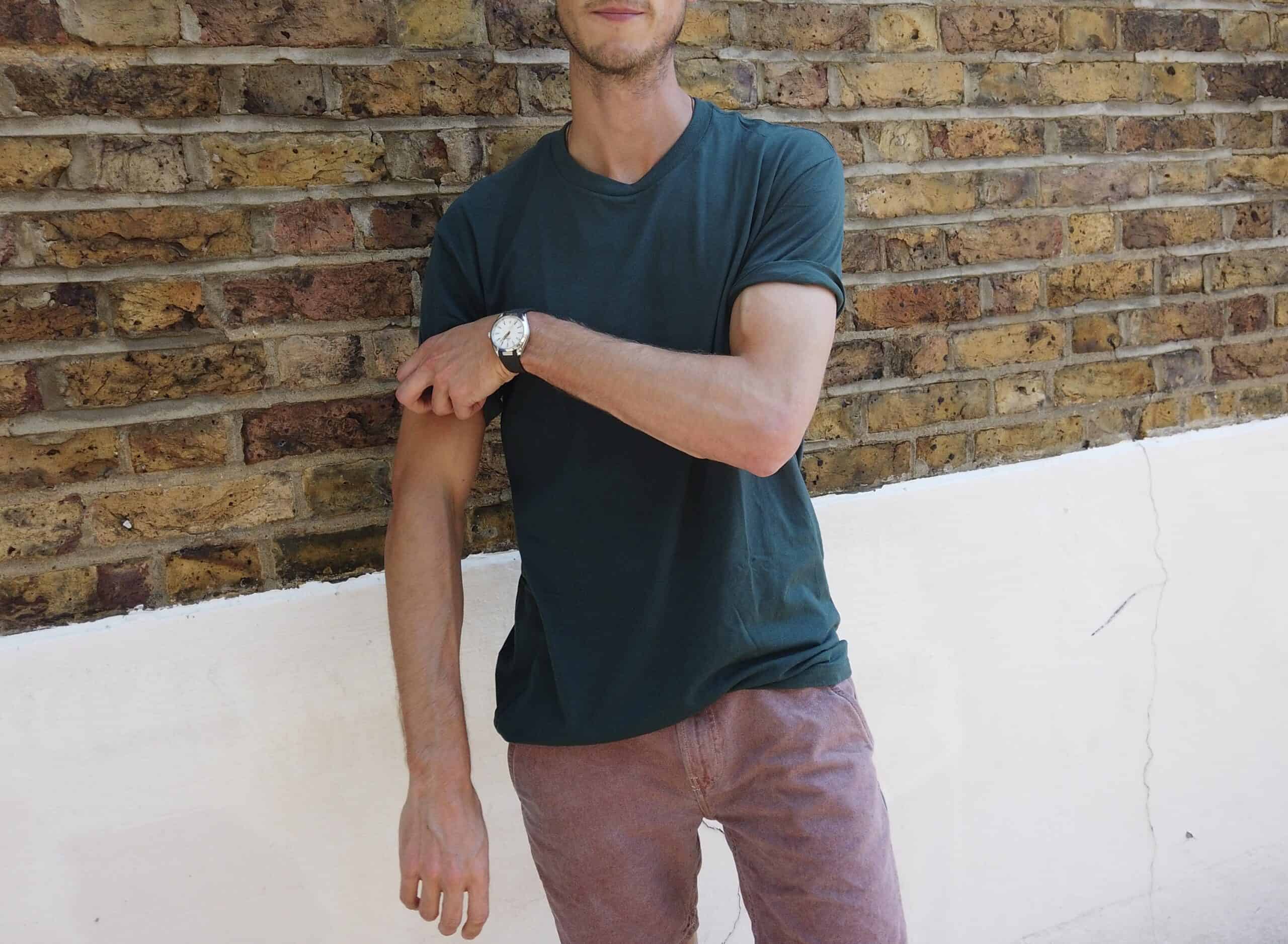 True Classic Tees dark green crew neck t-shirt worn by a model showcasing the tailored fit and casual style.