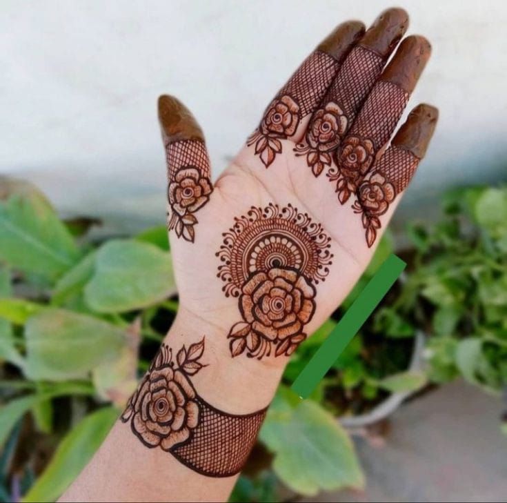 Floral Mehndi design with a central circular motif and mesh pattern on the fingers, perfect for modern brides and festive events.