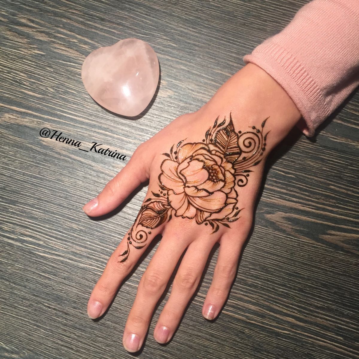 Large floral Mehndi design with intricate leaves and fine detailing on the back of the hand, ideal for festive occasions.