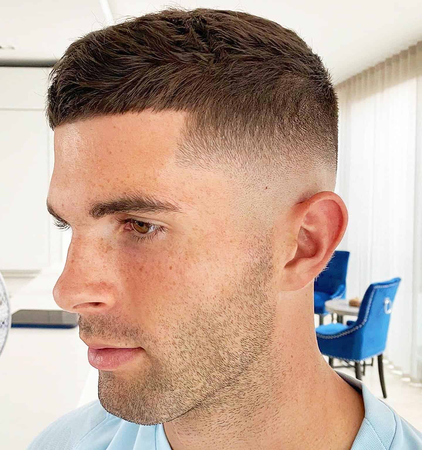 Side view of a clean men’s low fade haircut with a textured top and sharp edges