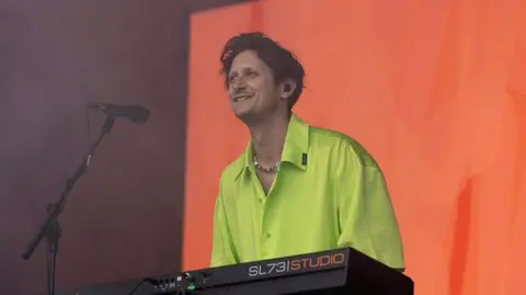 Barry Can't Swim, seen wearing a bagg lime green shirt, performing at Glastonbury Festival in June