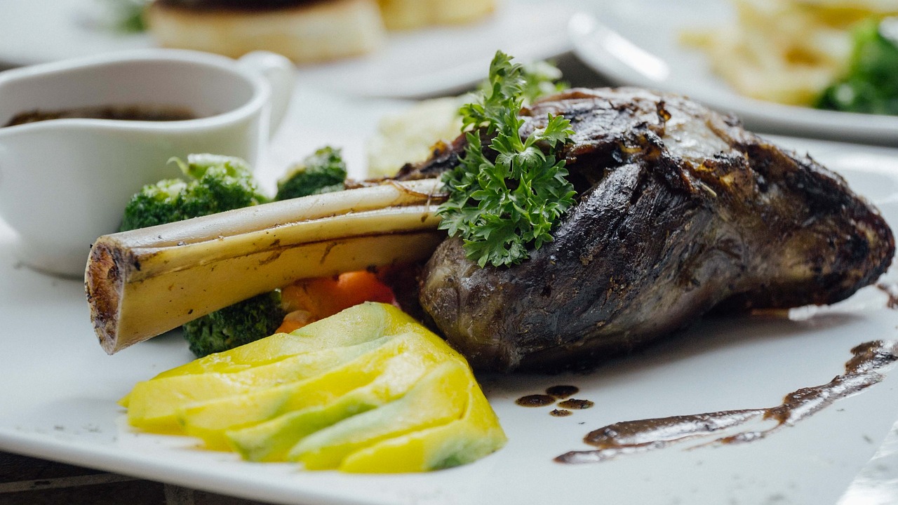 A plate of Turkish lamb shank served with vegetables and garnished with fresh herbs