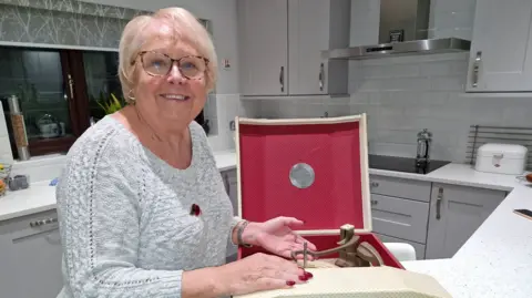 Mark Hammond Smiling Ellen Hammond stands next to her vintage record player