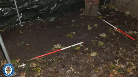 West Midlands Police Poles outlining where the body was buried in the garden