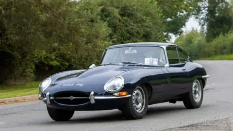 Getty Images A Jaguar E-Type being driven on a country road