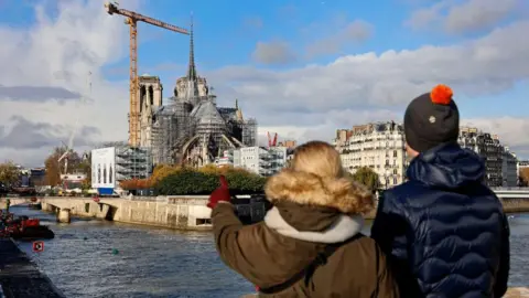 Getty Images People look at Notre Dame under scaffolding