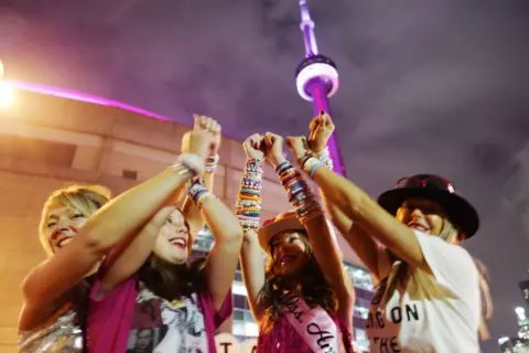 Getty Images A group of young fans display the friendship bracelets they've collected at a Taylor Swift concert