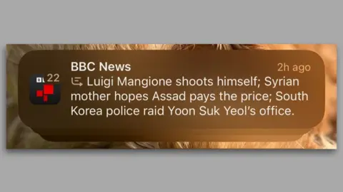 BBC News A zoomed-in phone screenshot of the misleading BBC notification from an iPhone. It reads: "BBC News, Luigi Mangione shoots himself; Syrian mother hopes Assad pays the price; South Korea police raid Yoon Suk Yeol's office".