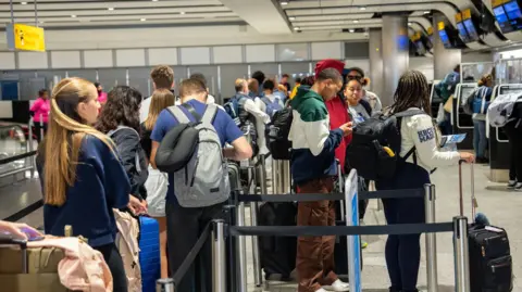 Getty Images People queueing at Heathrow Airport in 2023.