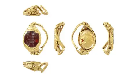 Andrew Williams/Norfolk County Council Six views of a gold Roman ring. Its front on the left reveals a red stone carved with a view of Diana pulling back her bow surrounded by its gold setting. The other views show how crumpled it has become over the centuries