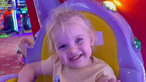 PA A close-up of Isabella Jonas-Wheildon sitting in an amusement ride while smiling into the camera