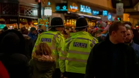 Getty Images Police officers walking through crowds at a Christmas market in Birmingham 