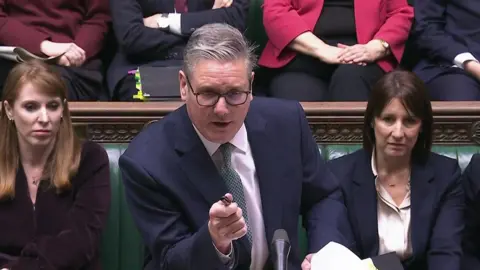 House of Commons/UK Parliament/PA Wire Leaning on the dispatch box, Keir Starmer is pictured in the House of Commons answering questions at PMQs, flanked by Angela Rayner and Rachel Reeves