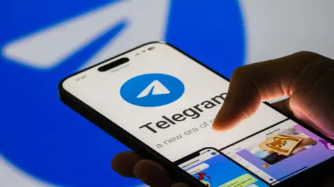 Getty Images A closeup of an iPhone in a person's hand showing a Telegram screen with the logo, which resembles a stylised paper plane in a blue circle