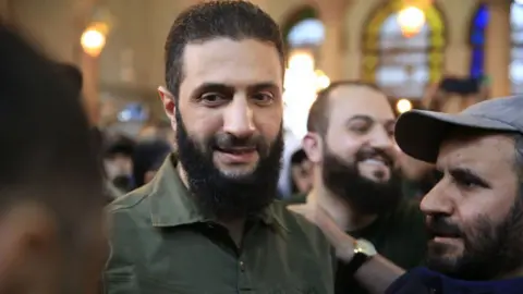 Getty Images Abu Mohammed al-Jawlani addressing crowds in a mosque in Damascus