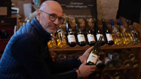 BBC Frédéric Brochet holding a bottle of alcohol-free wine