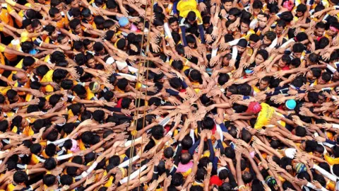 AFP Indian Hindu devotees gesture before attempting to form a human pyramid in a bid to reach and break a dahi-handi (curd-pot) suspended in air during celebrations for the Janmashtami festival, which marks the birth of Hindu god Lord Krishna, in Mumbai on August 18, 2014