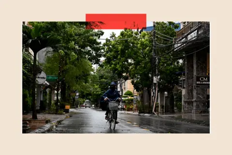 Getty Images A woman rides a bicycle on the street in Haiphong city