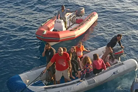 Handout Survivors on two dinghies. There are eight people on one vessel - it is not clear how many are survivors and how many are rescuers. There is one man in the other dinghy. 