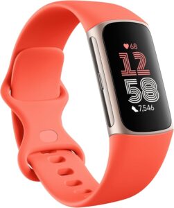 A coral pink Fitbit Charge 6 fitness tracker with a silver watch face