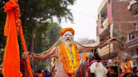 गेटी इमेजेज़ एक साधु, या हिंदू पवित्र व्यक्ति, 2 जनवरी को प्रयागराज में महाकुंभ मेला उत्सव से पहले, महानिर्वाणी अखाड़े के दौरान एक धार्मिक जुलूस के दौरान घोड़े पर सवार होता है, / गेटी इमेजेज़ के माध्यम से एएफपी)