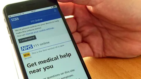 BBC The NHS app is seen on the screen of a smartphone.